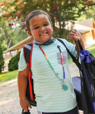 Boy with backpack and character bead necklace