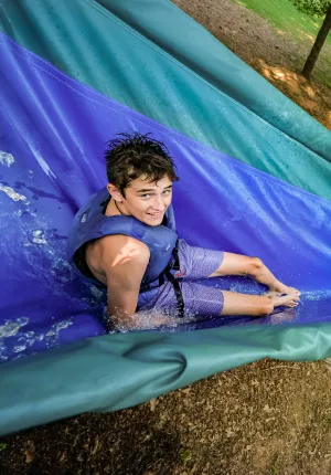 Boy on waterslide at camp Kanata