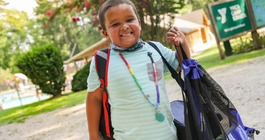 Boy with backpack and character bead necklace